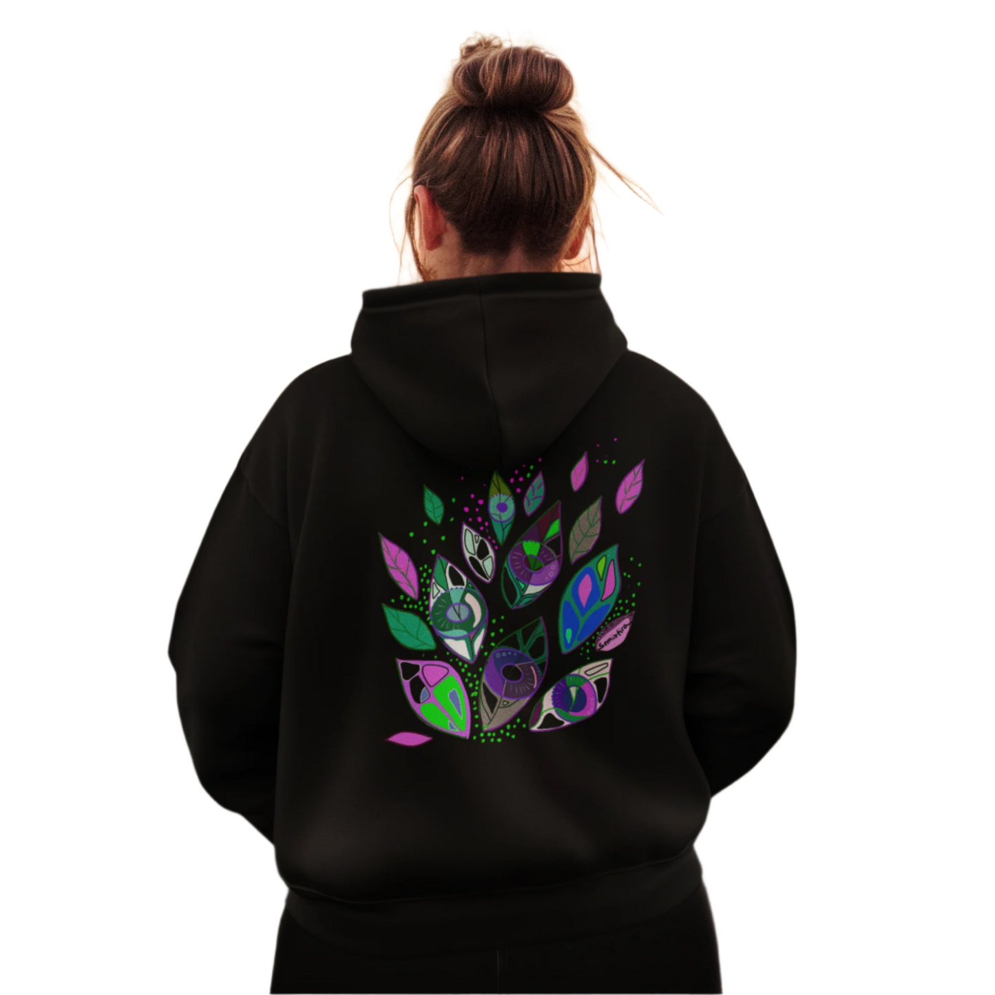 Woman wearing the Seeds of Seeing black hoodie with expressive symbolic print on the back.