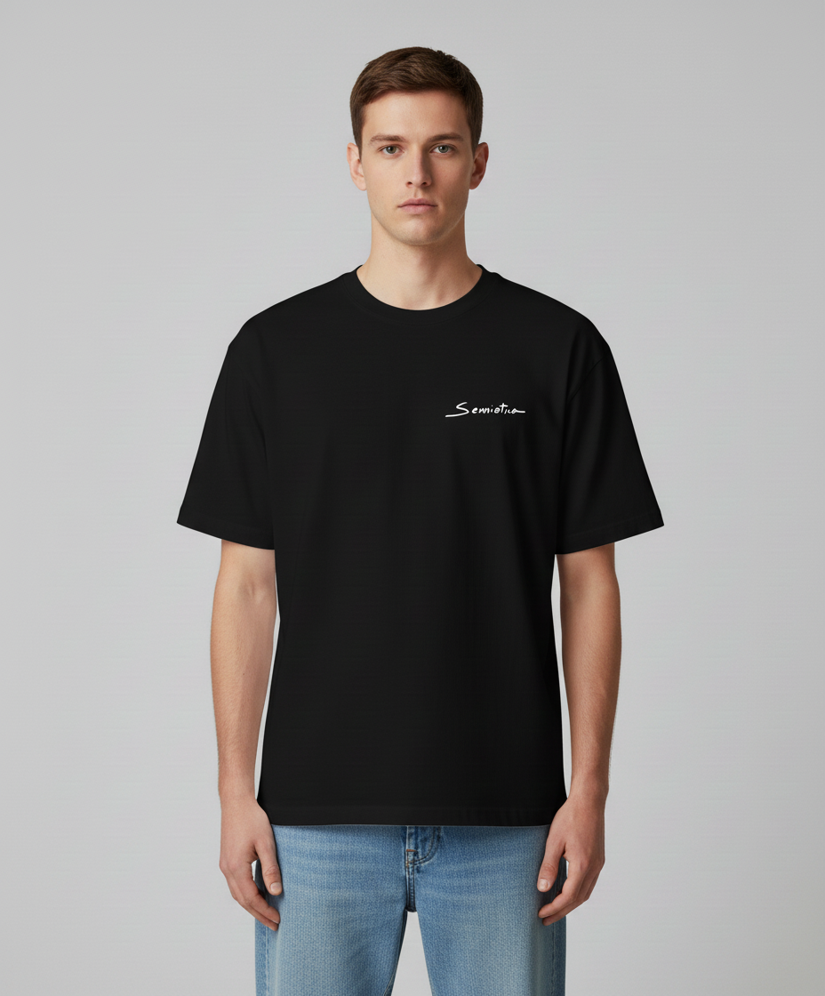 Man wearing a black t-shirt with Semiotica logo on white color on a gray background