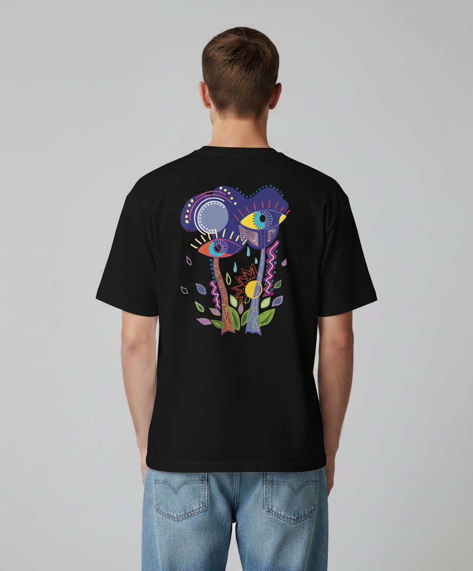A man wearing a black t-shirt from Semiotica with a colorful abstract design on the back against a gray background