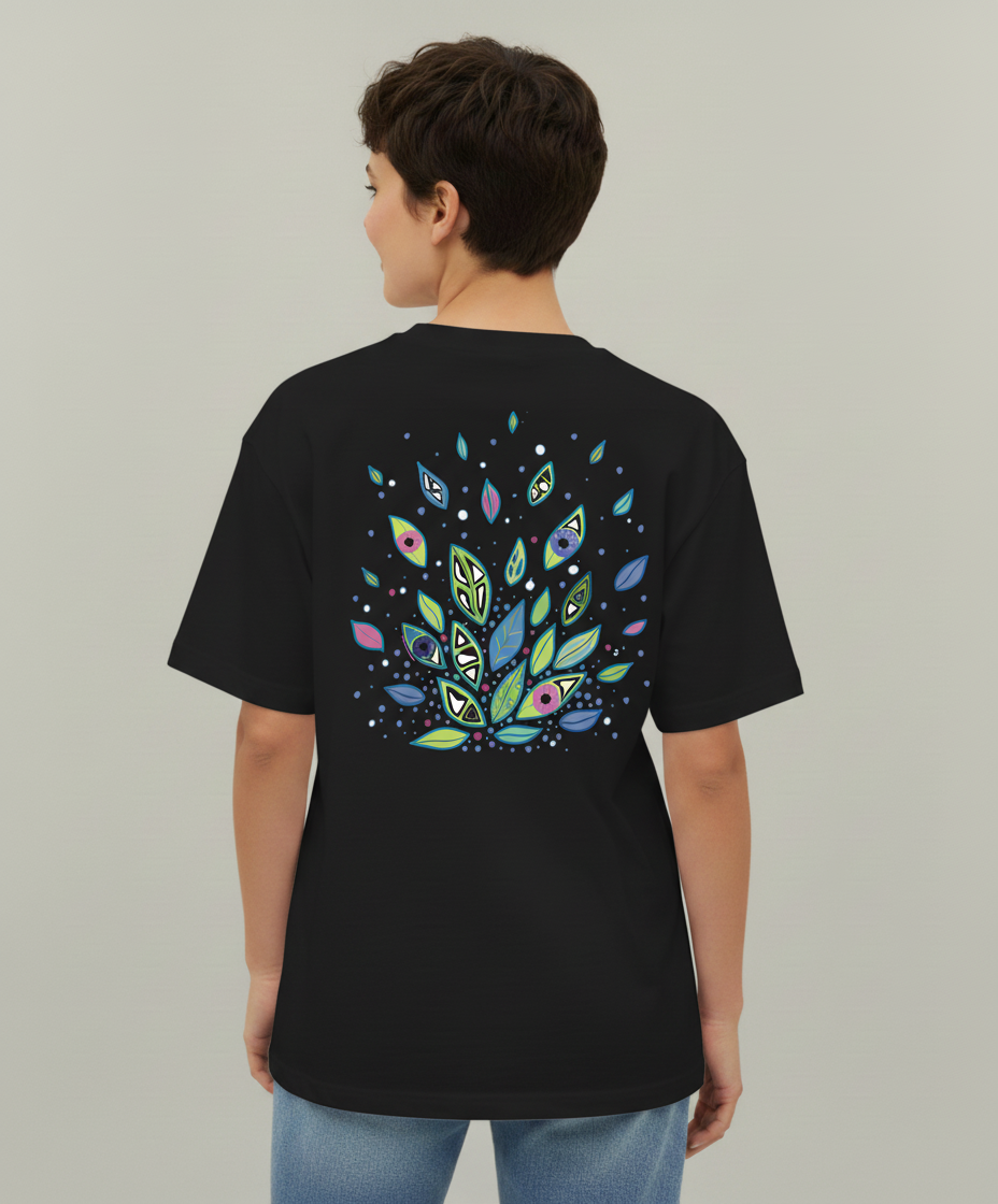 Woman wearing a black t-shirt from Semiotica with colorful leaf design on the back against a plain background