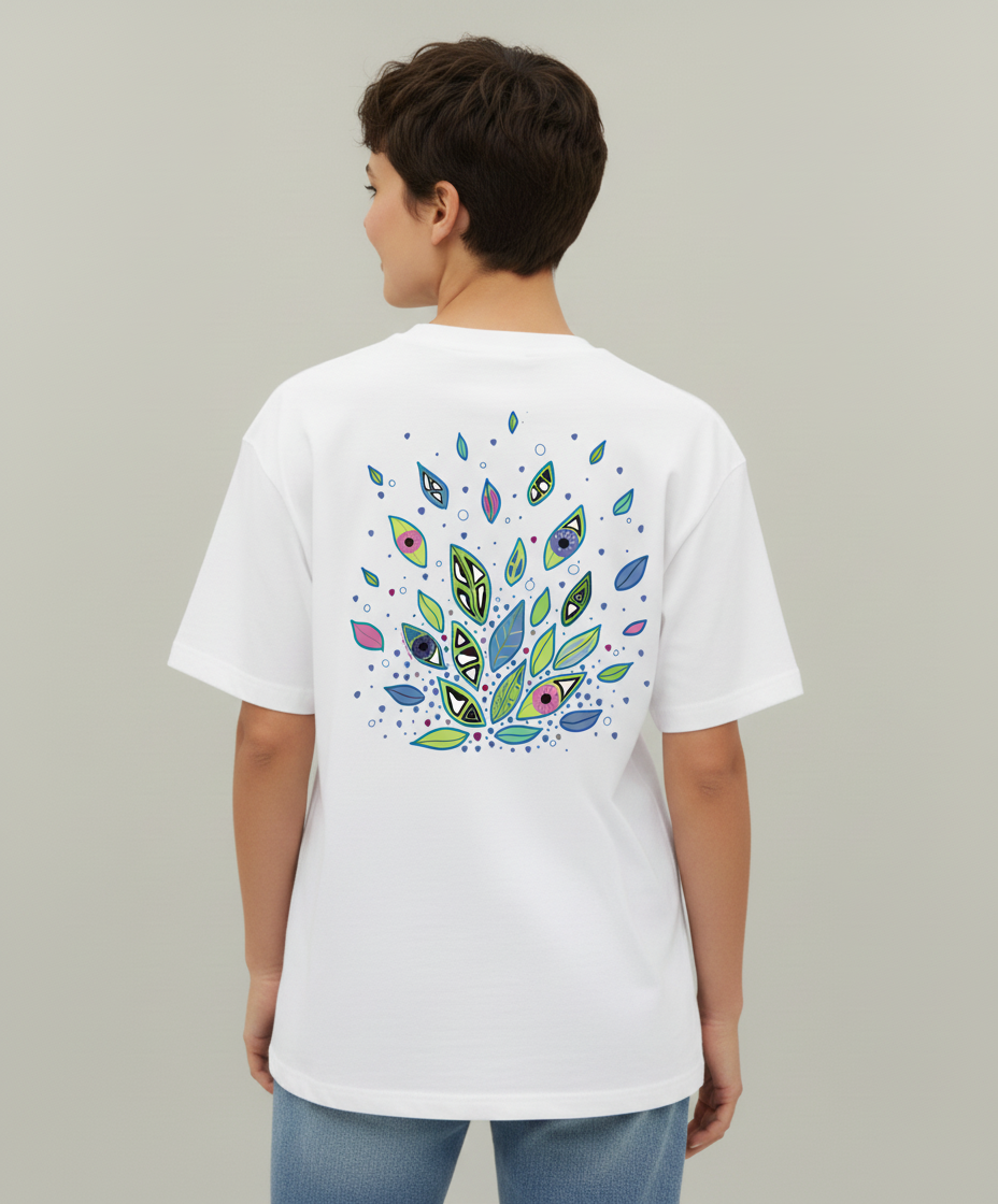 Woman wearing a white t-shirt from Semiotica with a colorful leaf pattern on the back against a plain background