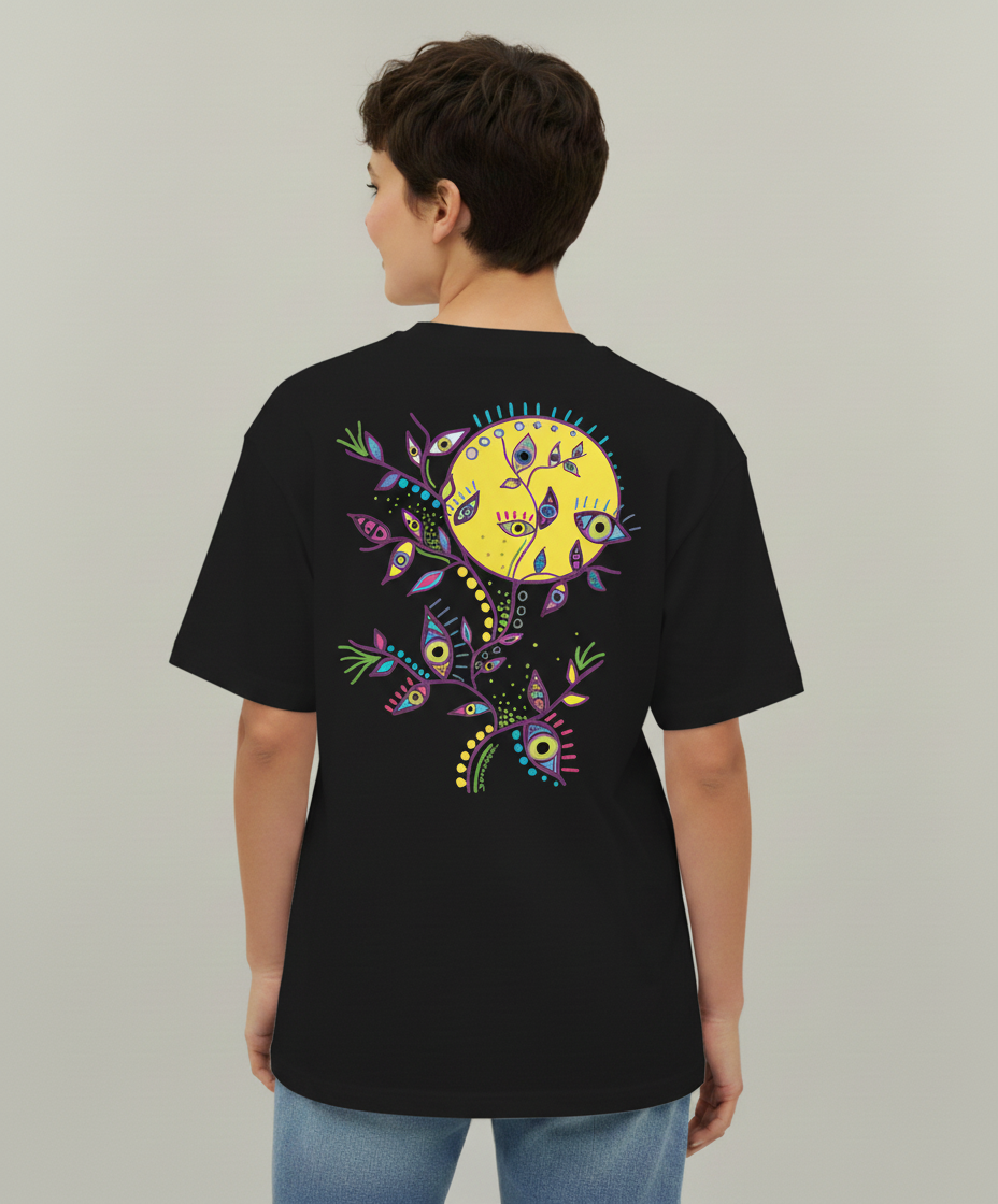 Woman wearing a black t-shirt from Semiotica with a colorful sun design on the back against a plain background