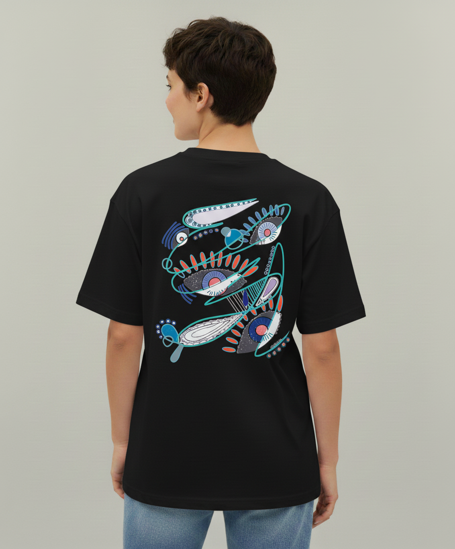 Woman wearing a black t-shirt from Semiotica with a colorful abstract design on the back against a plain background